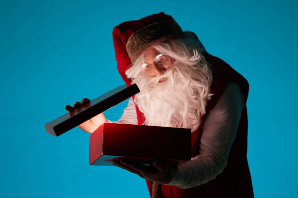 istock santa opens a magic box with a gift on a clean blue background, christmas gifts 1764582577