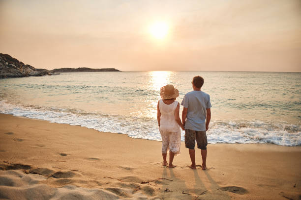 istock Senior couple enjoying walking along the beach 1764582584