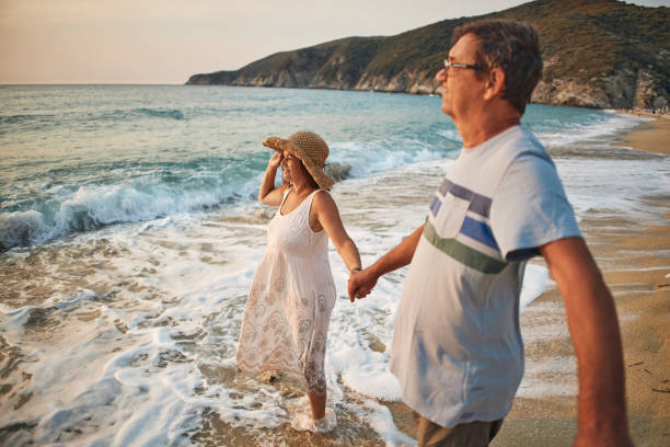istock Senior couple enjoying walking along the beach 1764583111
