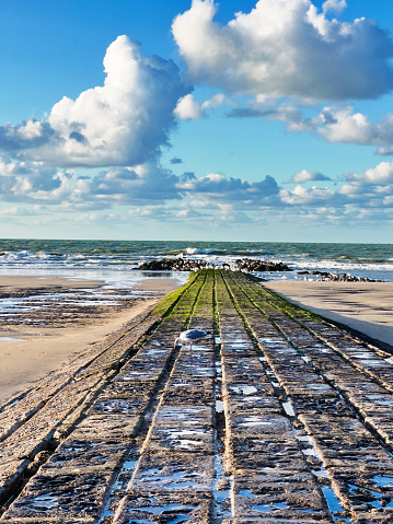 Stone breakwaterpartly covered with algae ,  at low tide in Middelkerke, a coastal community in West Flanders, Belgium.