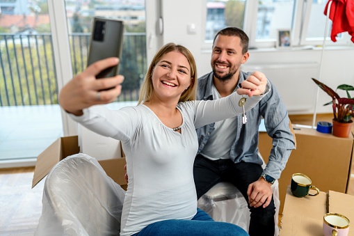 A couple is moving into a new apartment and taking a selfie