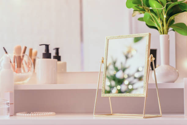 istock Reflection of christmas tree, light bulbs, in table mirror on woman dressing table with make up accessories 1764603638