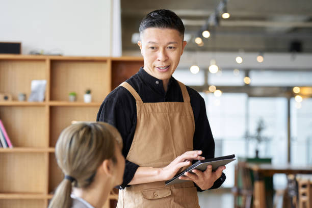istock Asian male clerk taking orders at a cafe 1764613617