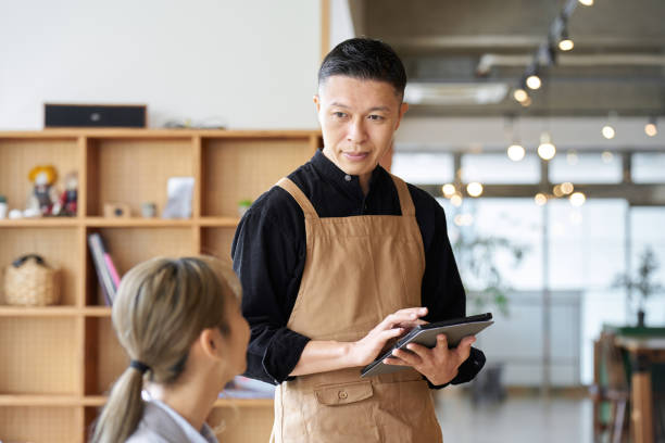 istock Asian male clerk taking orders at a cafe 1764614823