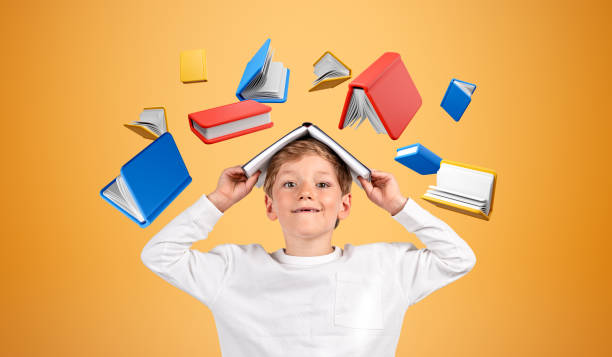 istock Kid with book on head on yellow background, learning and reading 1764635354