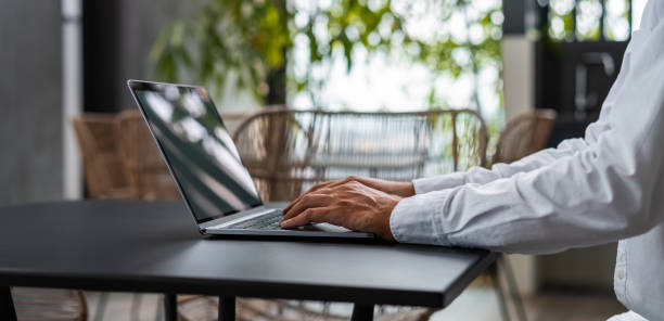 istock Man hands typing on the laptop keyboard with cafe on background 1764643585