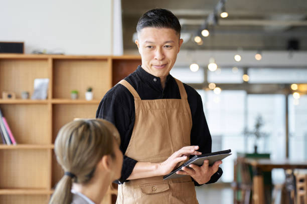 istock Asian male clerk taking orders at a cafe 1764658836