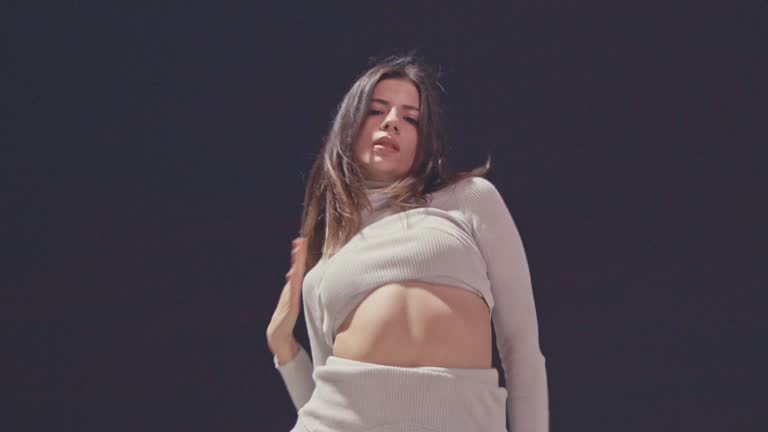 Young attractive woman dancing freely on the coastline