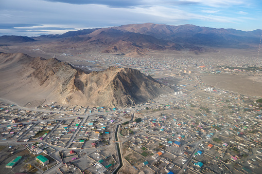Aerial view from an aeroplane, looking down on the Altai Mountains city of Ulgii, in Western Mongolia. It is the capital of the Bayan-Ulgii province, which is the Kazakh region of Mongolia. The local population is mainly Kazakhs, who live in the city, or as nomadic herders or traditional eagle hunters in the more remote and rural areas of the mountainous region, which borders with China and Russia.