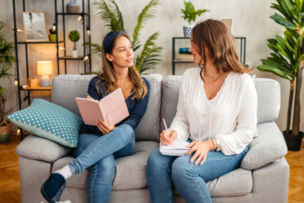 istock Two Female Friends Studying Together On The Sofa At Home 1764681065