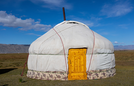 A picture of the nomadic family in the serene Tuv steppe, Mongolia. The family lives alone in the vast steppe. They moves out to other steppes each year.