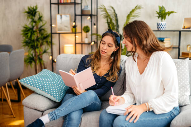 istock Two Female Friends Studying Together On The Sofa At Home 1764687359