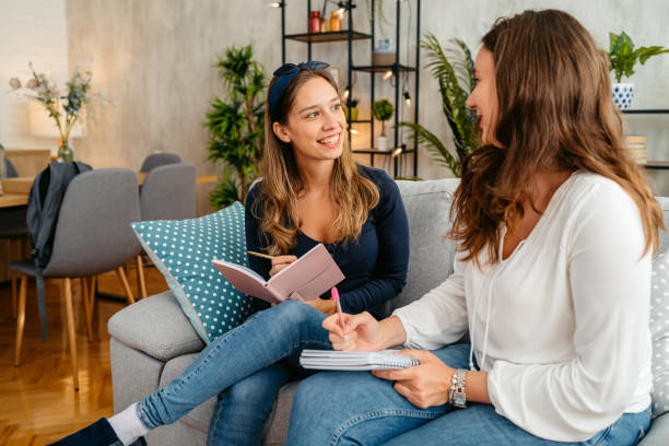 istock Two Female Friends Studying Together On The Sofa At Home 1764689086