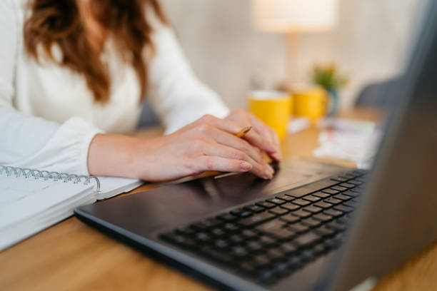istock Young Woman Working On A Laptop At The Kitchen Table 1764693554