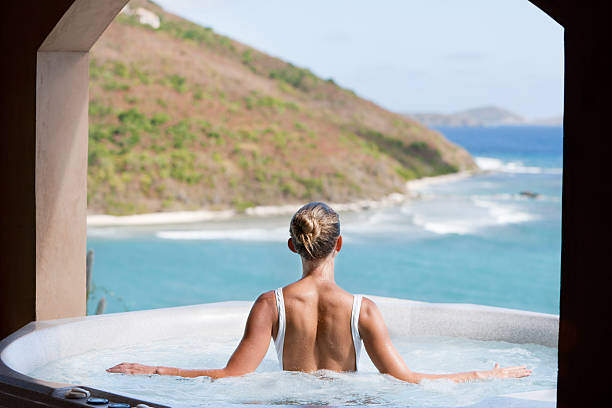 unrecognizable woman soaking in a hot tub with the Caribbean views stock photo