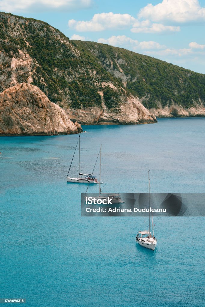 Aerial view of yachts in Ionian sea in Lefkada, Greece Drone view of boats sailing in turquoise sea by cliffs Adventure Stock Photo