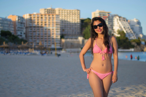 Beautiful latin girl by the poolside on a sunny late afternoon. Picture was taken at Magalluf beach in Mallorca Spain.