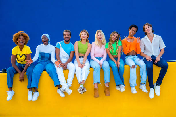 Young people sitting on yellow retaining wall