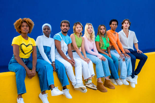 istock Serious group of multi-ethnic young people sitting on a wall 1764728703
