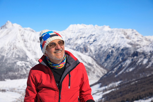 Active lifestyle, Portrait Vital senior  men snow skier, enjoying on sunny ski resorts.  Snowcapped mountain  Alps  ski area. Ski resort Livigno. italy, Europe.