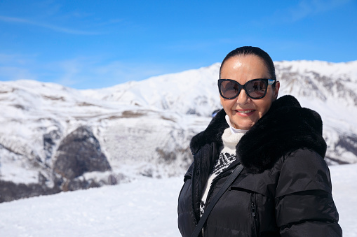 Active lifestyle, Portrait Vital senior  women snow skier, enjoying on sunny ski resorts.  Snowcapped mountain  Alps  ski area. Ski resort Livigno. italy, Europe.