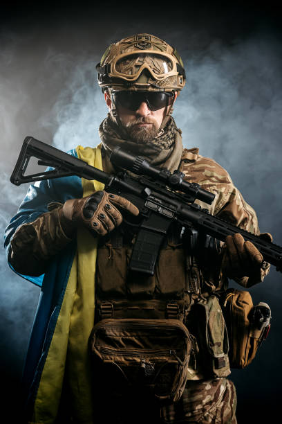 istock Private security contractors, elite special forces, Ukrainian soldier with full protection and Ukrainian flag in a combat zone. The concept of a strong country and invincible people. 1764745532