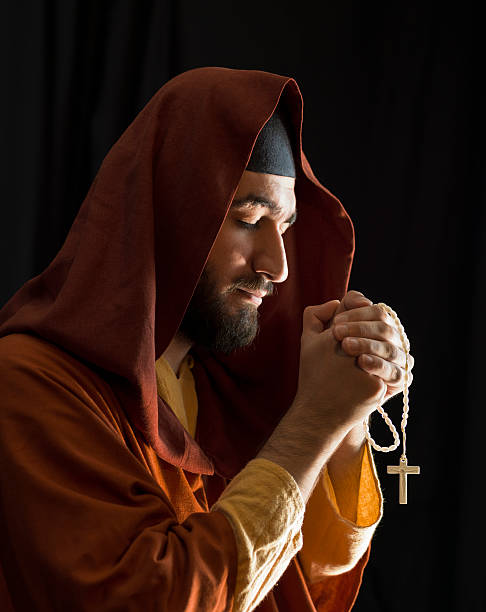 istock Christian Priest holding cross and praying 176475539