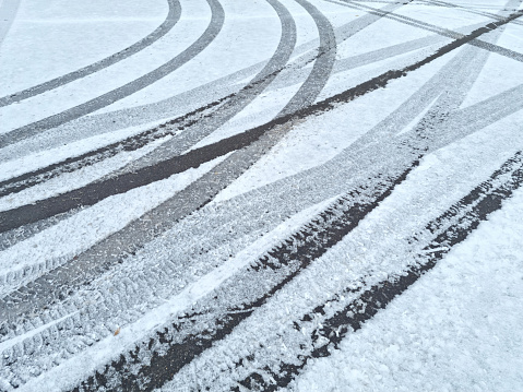 Dynamic car tread marks on the snow. Early winter. Energy and expression of movement. Black and white wheel print graphics