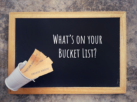 WHAT’S ON YOUR BUCKET LIST written on a blackboard. With blurred styled background.