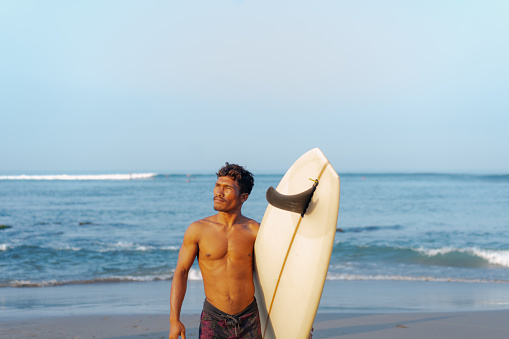 Group of Multicultural Friends Surfing in Canggu Beach Bali