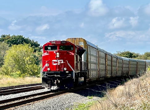 clarington, canada - september 07 2023: an engine of canadian pacific is driving on a railroad pulling a long cargo train