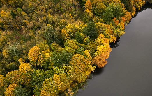 Lake surrounded by trees in the colors of autumn. The lake is called the typical name Long Lake \