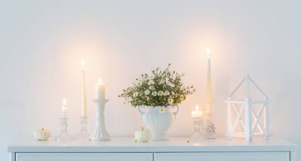 istock white flowers in white ceramic vase with burning candles in white interior 1764794048