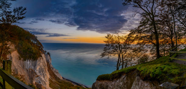 dawn over the stunning white chalk cliffs of møn island. sunrise over the enchanting møn island on the danish coast, casting a magical light on the majestic white chalk cliffs, møns klint. - white cliffs imagens e fotografias de stock