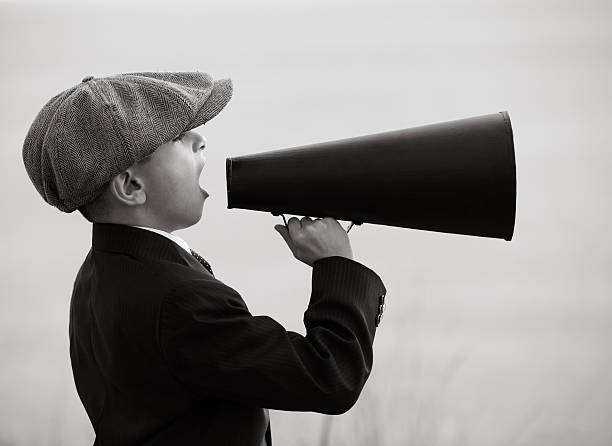 istock Little Boy With Newsboy Cap Shouting On Old Fashioned Megaphone 176480800