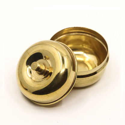 a traditional golden brass box bowl with lid used to store food spice and powder isolated in a white background in closeup