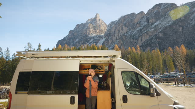 Woman in camper van on the background of Dolomites in autumn