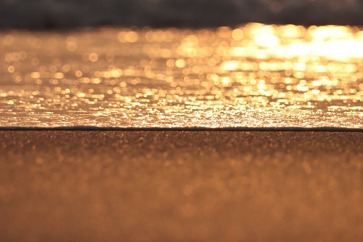 Ocean blurred waves golden bokeh, light, background.