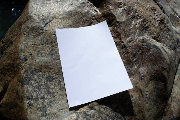 istock Mockup sheet on large mountain stones in diffused sunlight. Layout of poster on stone 1764839422