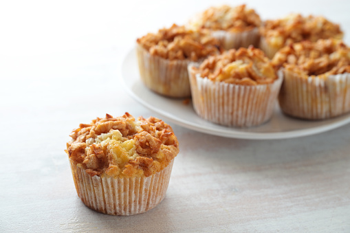 Juicy muffins with apple and cinnamon, sweet homemade pastry, seasonal baking in autumn, copy space, selected focus, narrow depth of field