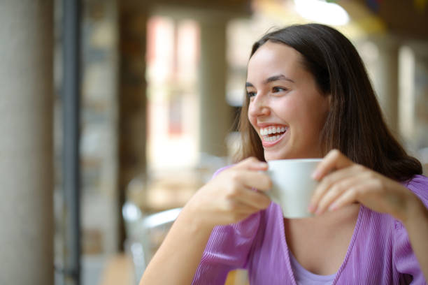 istock Happy woman at breakfast drinking coffee laughing 1764891727