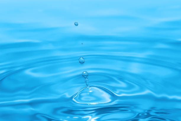 istock A water droplet falling into a tranquil body of water, creating ripples and splashes 1764896549