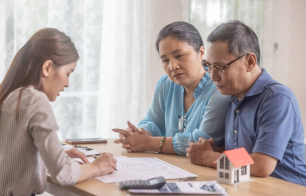 istock Elderly couples satisfying retirement home purchase with contract and key handover from a saleswoman 1764906871