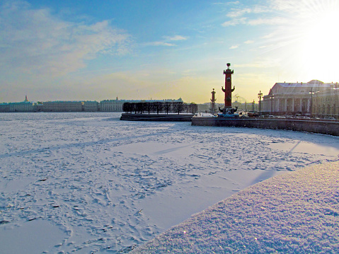 Panorama with buildings on the embankment in the distance. Ice and snow are in the foreground.