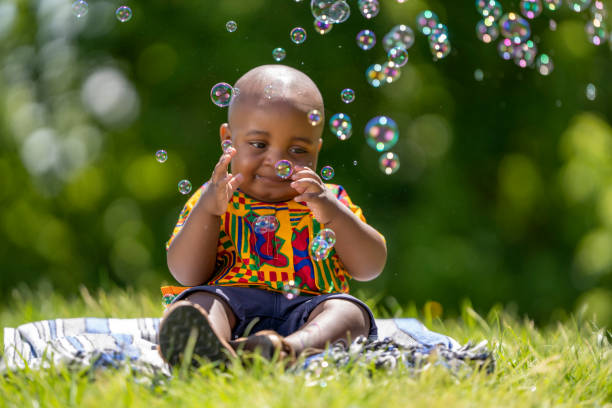 istock Little black-skinned boy playing in the park with soap bubbles 1764942446