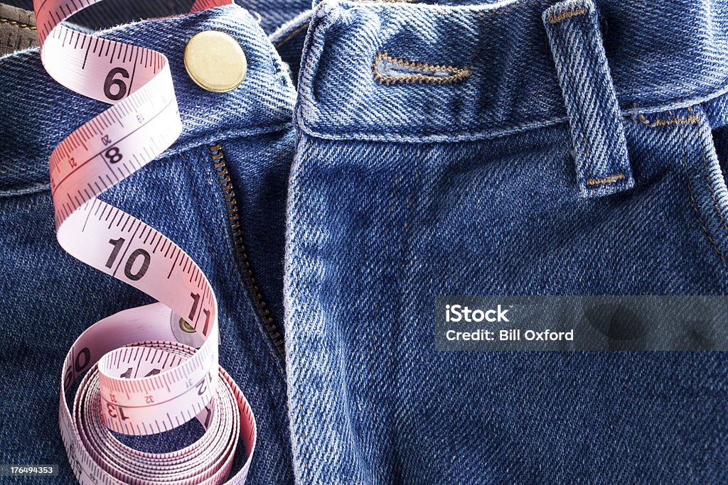 Tailor close up of blue jeans with measuring tape, concept for tailor or size of manhood. Penis Stock Photo