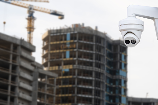 security cctv camera or surveillance system with construction site on blurred background