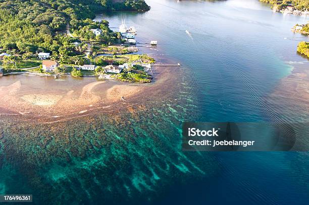 Aerial View Of A Colorful Tropical Reef And Nearby Village Stock Photo - Download Image Now