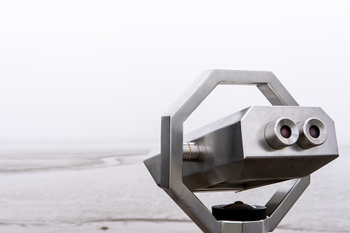 Close-up view of binoculars on a viewing platform in fog in the Wadden Sea