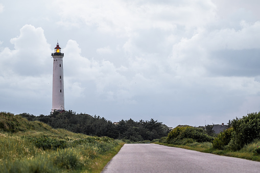 The majestic Hvide Sande Lighthouse stands tall on the Danish coast, a symbol of maritime heritage and safety. Its bold red and white stripes contrast beautifully against the coastal landscape. This image encapsulates the enduring charm and navigational significance of the Hvide Sande Lighthouse, inviting travelers to explore the stunning shores of Denmark.